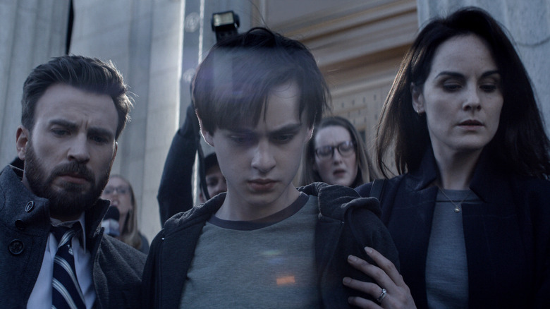Jacob, with his parents, cuts through the crowd outside the courtroom in "Defending Jacob" (2020)