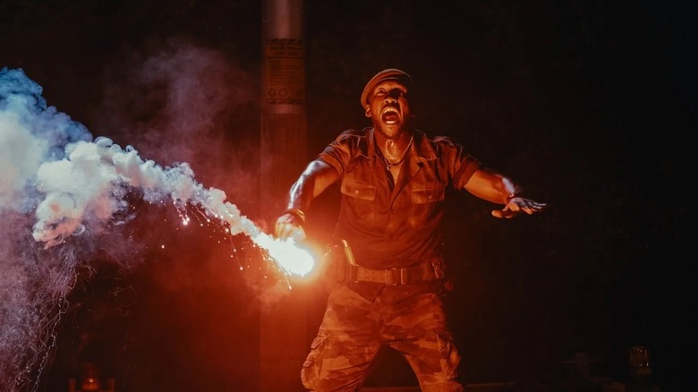 Duncan holding a flare at night in Jurassic World Rebirth (2025)