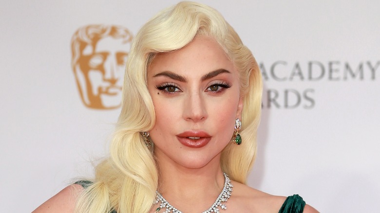 Lady Gaga with blonde hair and green earrings