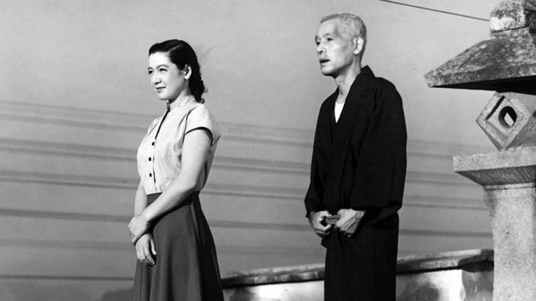 Family members standing next to a shrine in Tokyo Story
