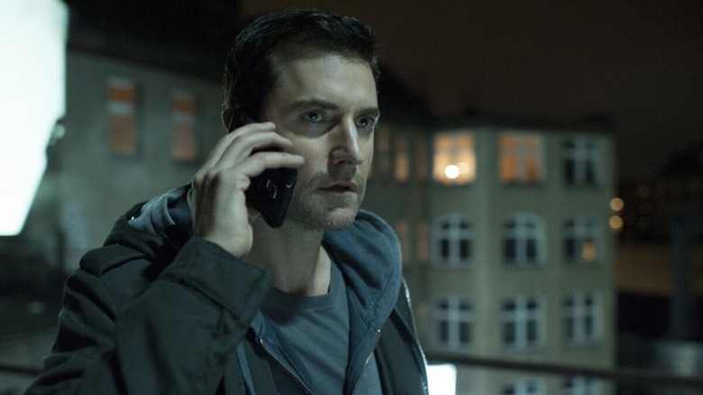 Miller talks on a cell phone and looks worried.