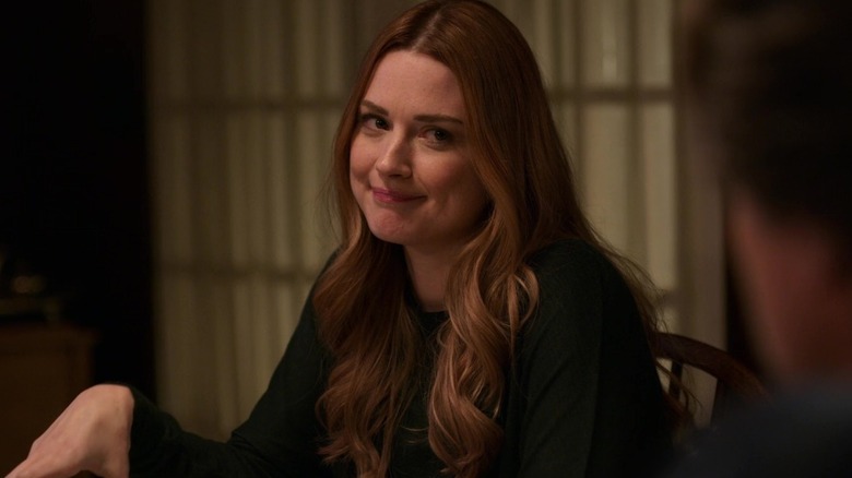 Melinda sits and smiles at the kitchen table in "Virgin River" (2019-present)