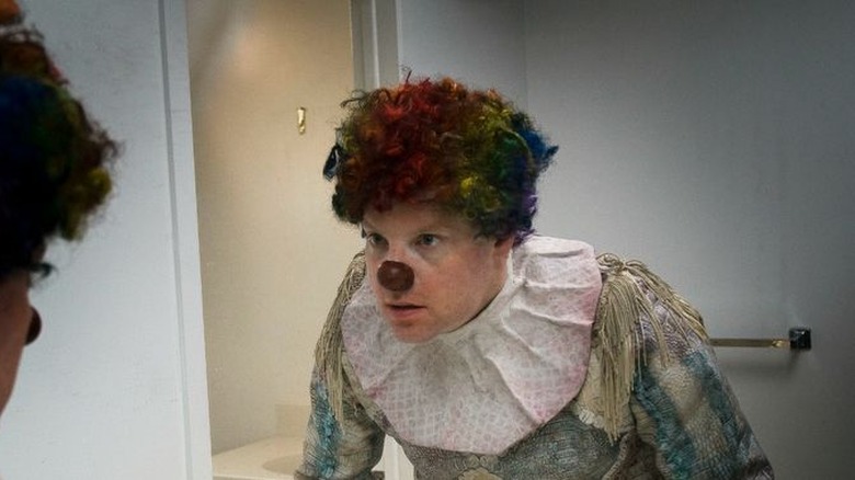Clown looks in the mirror