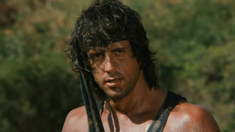 Rambo stands in the forest in 