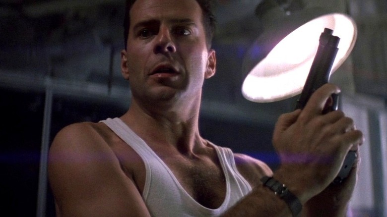 John McClane holds gun in "Die Hard" (1988)