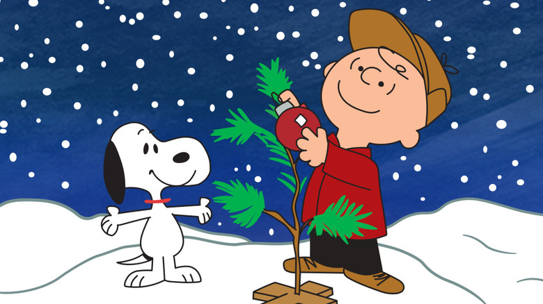 Charlie Brown puts a bauble on a small Christmas tree as Snoopy watches in A Charlie Brown Christmas