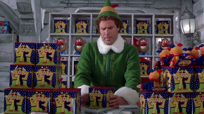 Buddy arranges toys on a shelf in Elf