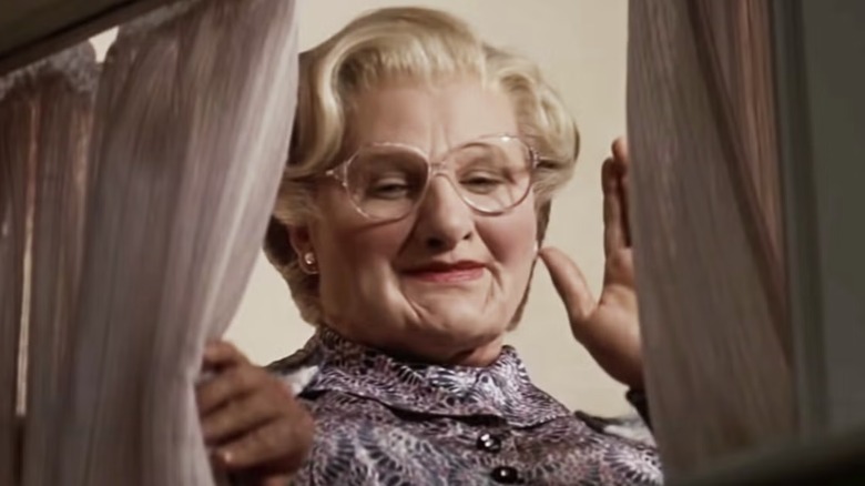 Mrs. Doubtfire waves to someone behind a curtain in "Mrs. Doubtfire" (1993)