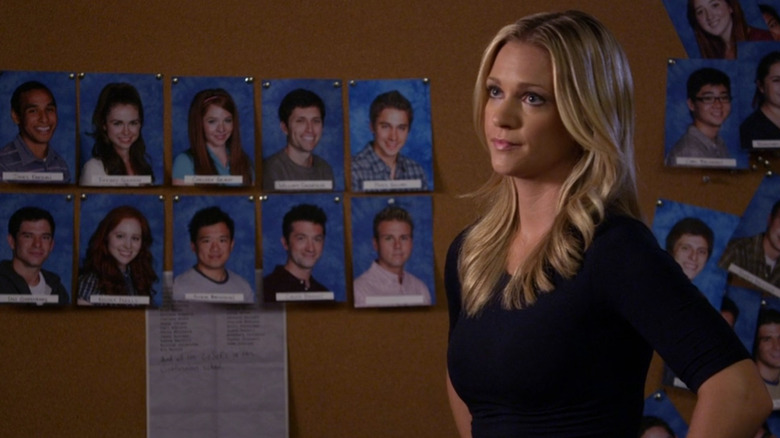 JJ standing in front of a board that displays yearbook photos