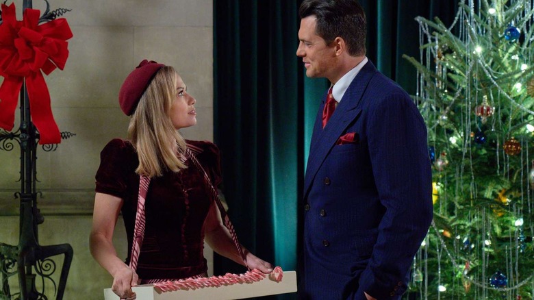 Lucy holds a tray of candy canes while Jack smiles at her.