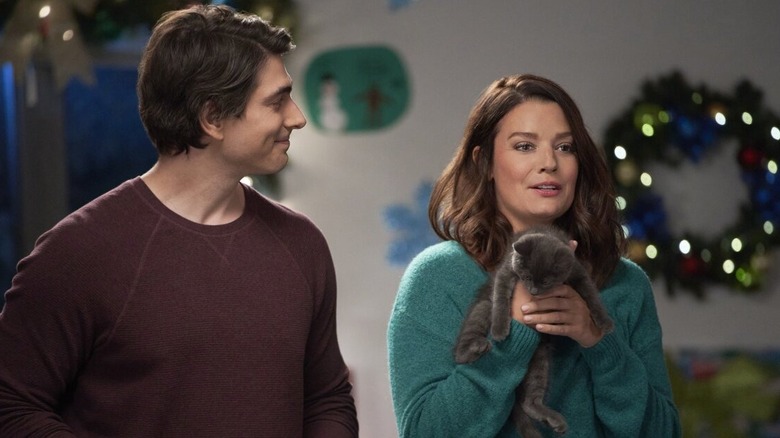 Zach smiles at Marily holding a kitten.