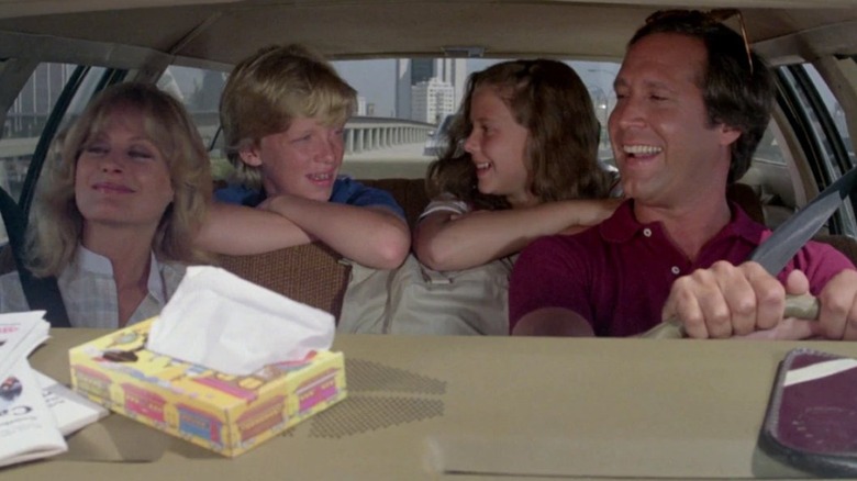 The Griswold family smiling in the car together in National Lampoon's Vacation (1983)