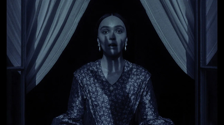 Ellen with the shadow of Orlok's hand over her face in a window in Nosferatu