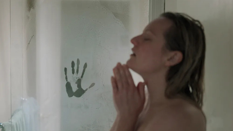 Cecelia showering next to a handprint on the window in The Invisible Man