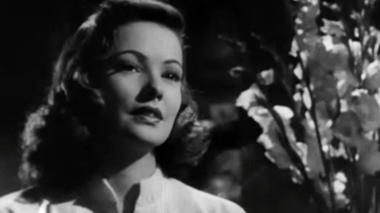 Laura standing beside flowers in "Laura" (1944)
