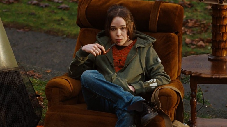 Juno sits in a chair and holds a pipe in Juno (2007)