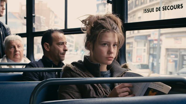 Adèle looks up from book on bus