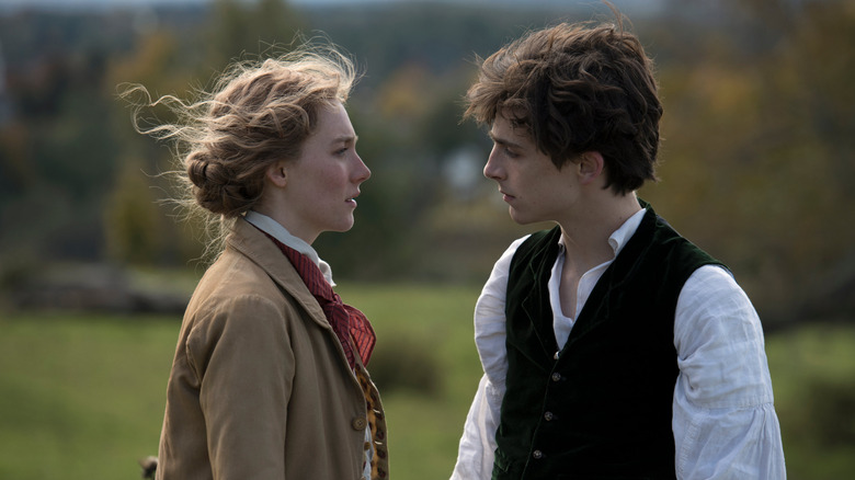 Saoirse Ronan as Jo facing Timothee Chalamet as Laurie in a field in Little Women (2019)