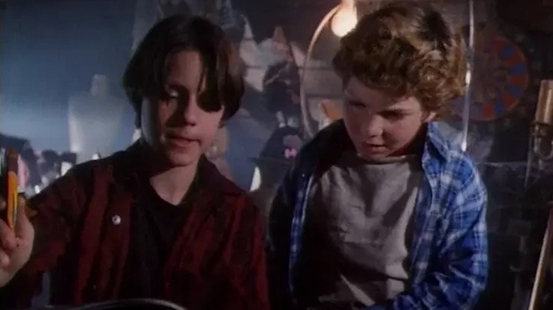 Marshall and Simon flip through an old book in a dank basement in Eerie, Indiana