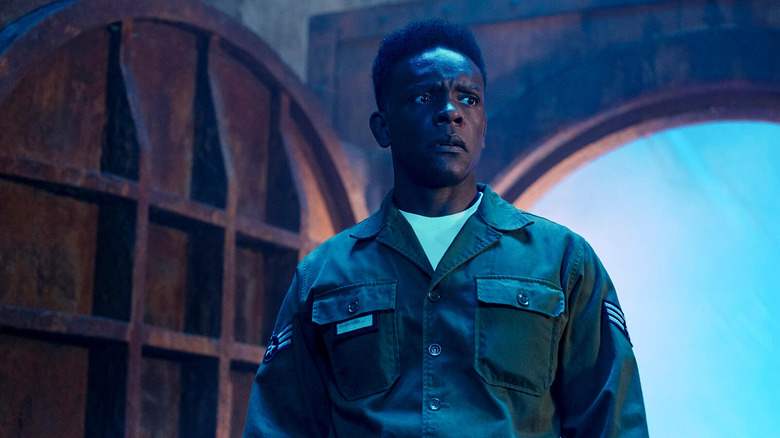 Dick walks through a circular door and looks worried in It: Welcome to Derry