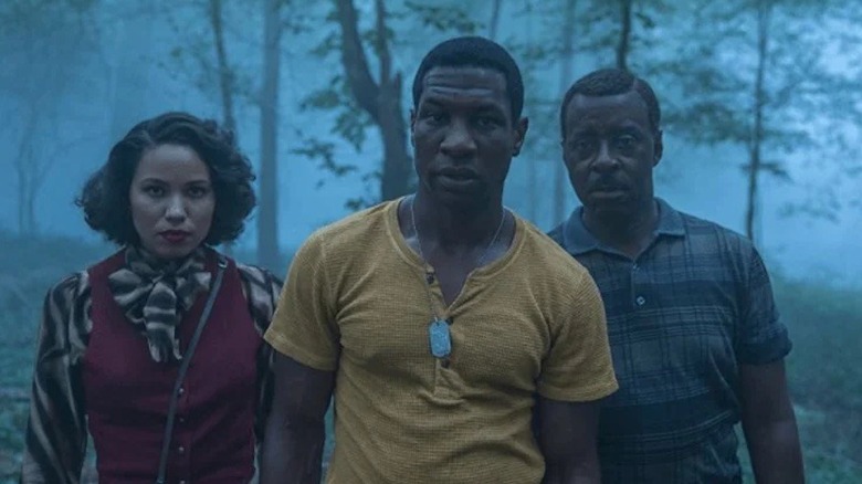 Atticus, Letitia, and George walk through a misty forest in Lovecraft Country