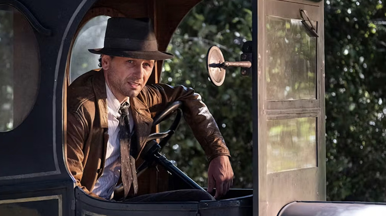 Perry leans on the steering wheel of his Model T in "Perry Mason" (2020-2023)