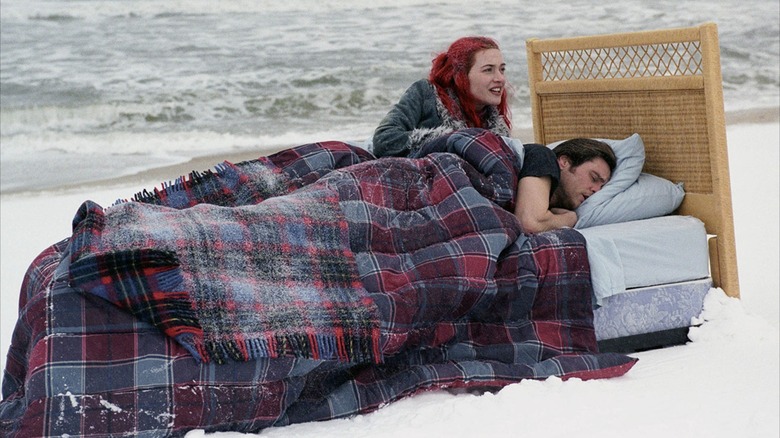 Joel Barish and Clementine Kruczynski lying in bed on a beach in "Eternal Sunshine of the Spotless Mind"