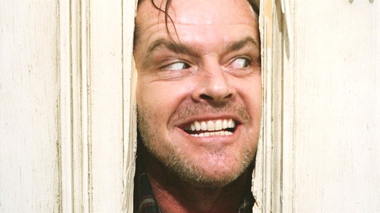 Jack Torrance looks through a hole in a door in "The Shining" (1980)