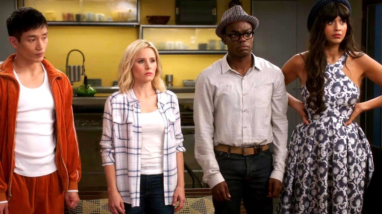 Jason, Eleanor, Chidi, and Tahani standing in row Eleanor's kitchen looking worried