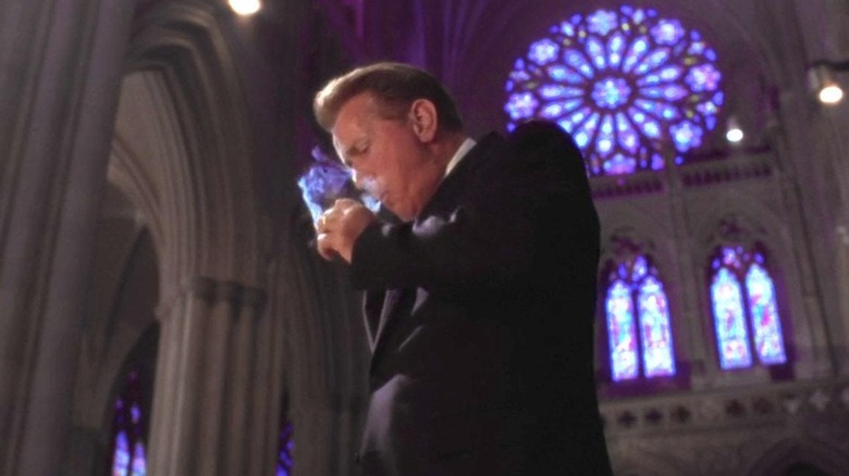 President Jed Bartlett smoking a cigarette in an enormous cathedral with stained-glass windows