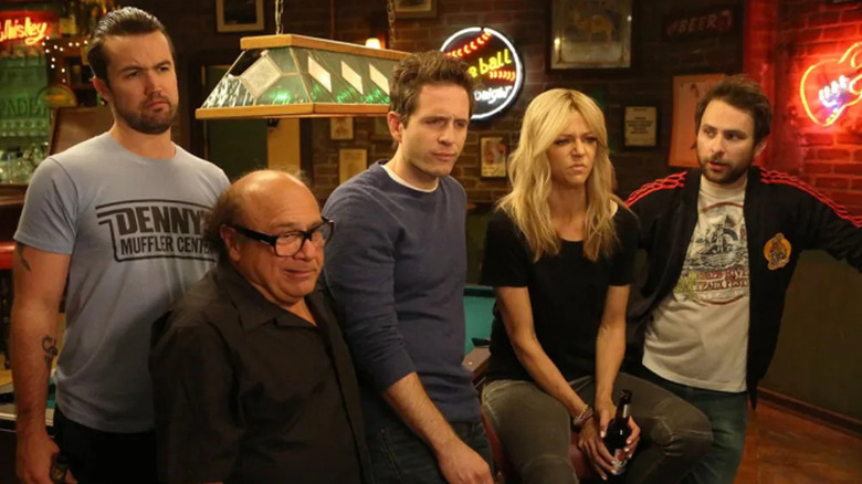 The gang gathers around a pool table and scowls at something offscreen in It's Always Sunny in Philadelphia.