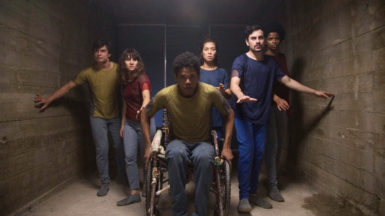 The characters walk through a narrow concrete corridor in "3%" (2016-2020)