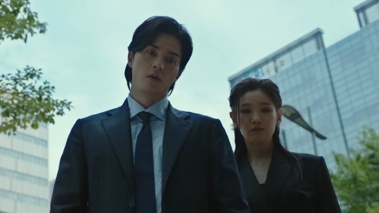 Tae-u and Death stand in a city street looking down on "Death's Game" (2023-2024)