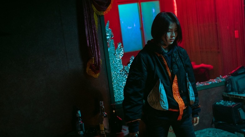 Ji-woo stands in front of a broken window on "My Name" (2021)