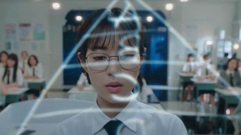Do-ah writes on the blackboard while the other students watch on "Pyramid Game" (2024)