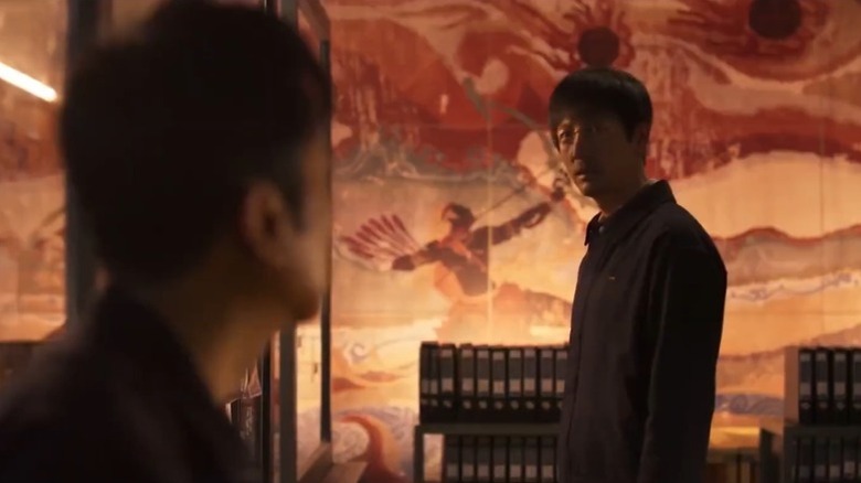 Wang Miao stands next to a painted wall and staring at Shi Qiang on "Three-Body" (2023)