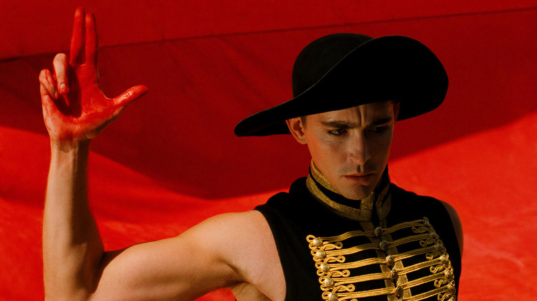 The Black Bandit stands in front of a red flag in 'The Fall' (2006)
