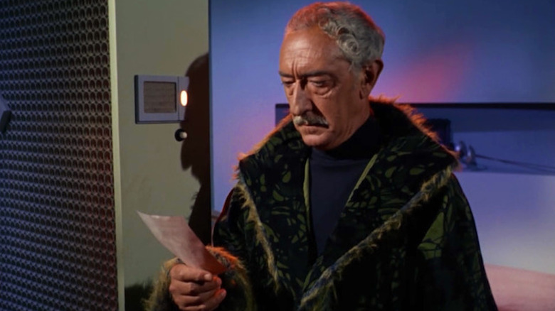 Kodos looks at a printed paper in Star Trek