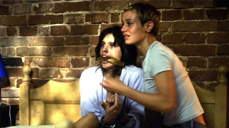 A gagged Alex and Marie sitting on a bed in "High Tension"