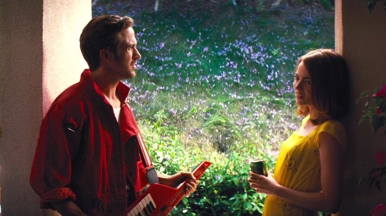 Sebastian plays a keyboard as Mia drinks from a can