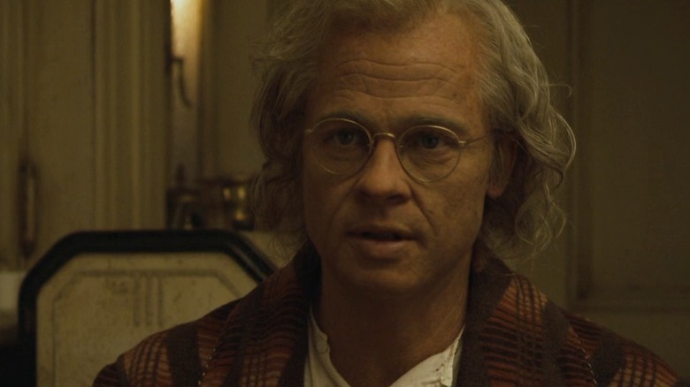 Benjamin Button sitting at a table and staring ahead in The Curious Case of Benjamin Button