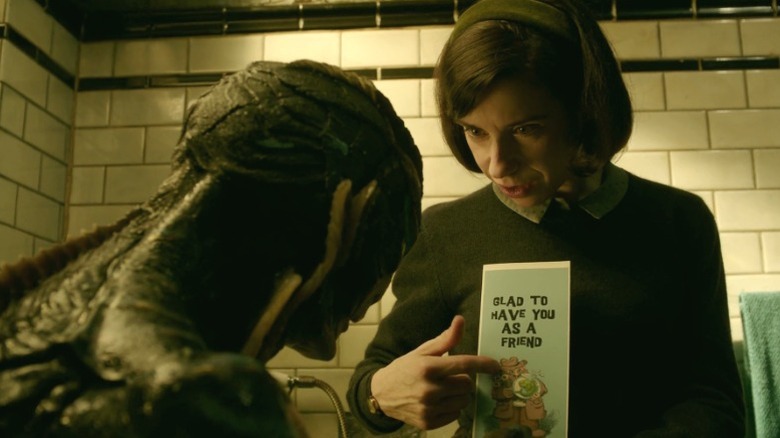 Elisa Esposito showing the amphibian man a card that says "Glad to have you as a friend" in The Shape of Water
