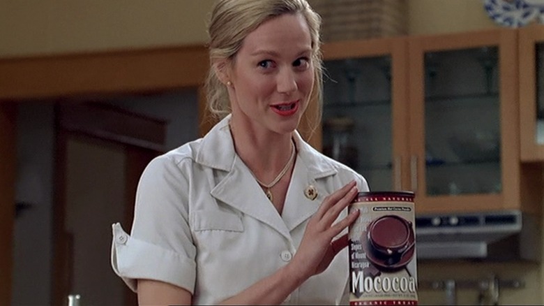 Truman's wife holding up a tin of Mococoa mix in the kitchen in The Truman Show