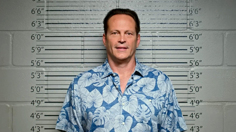 Andrew Yancy has his mug shot taken while wearing a blue Hawaiian shirt in "Bad Monkey"