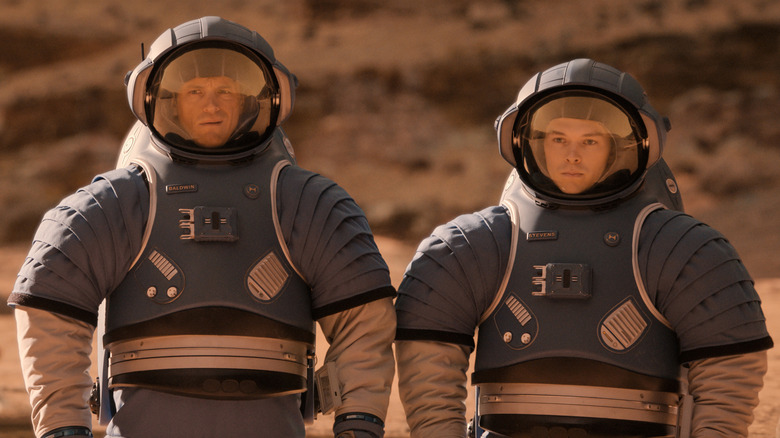 Edward Baldwin and Danny Stevens wear blue space suits on the rocky terrain of Mars in "For All Mankind"