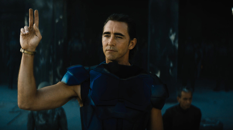 Brother Day holds up his hand while wearing blue armor in "Foundation"