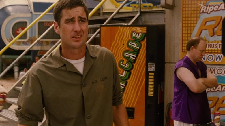 Joe walking through a city filled with trash and ads in "Idiocracy"