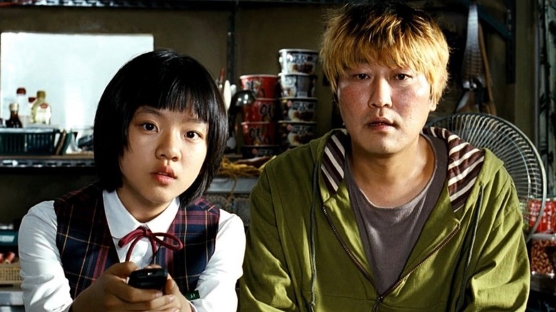 Gang-du and Hyun-seo sitting on the couch together in The Host