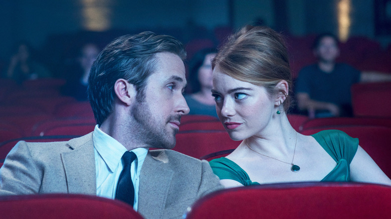 Seb and Mia look at one another in a movie theater in "La La Land"