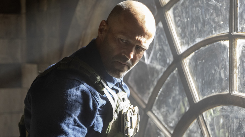 Levon Cade glancing back away from window in A Working Man